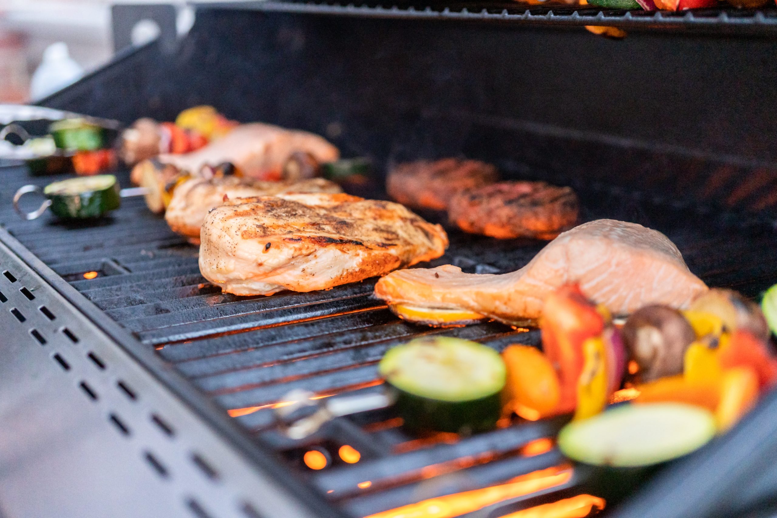 assortment of meats over grill top fire