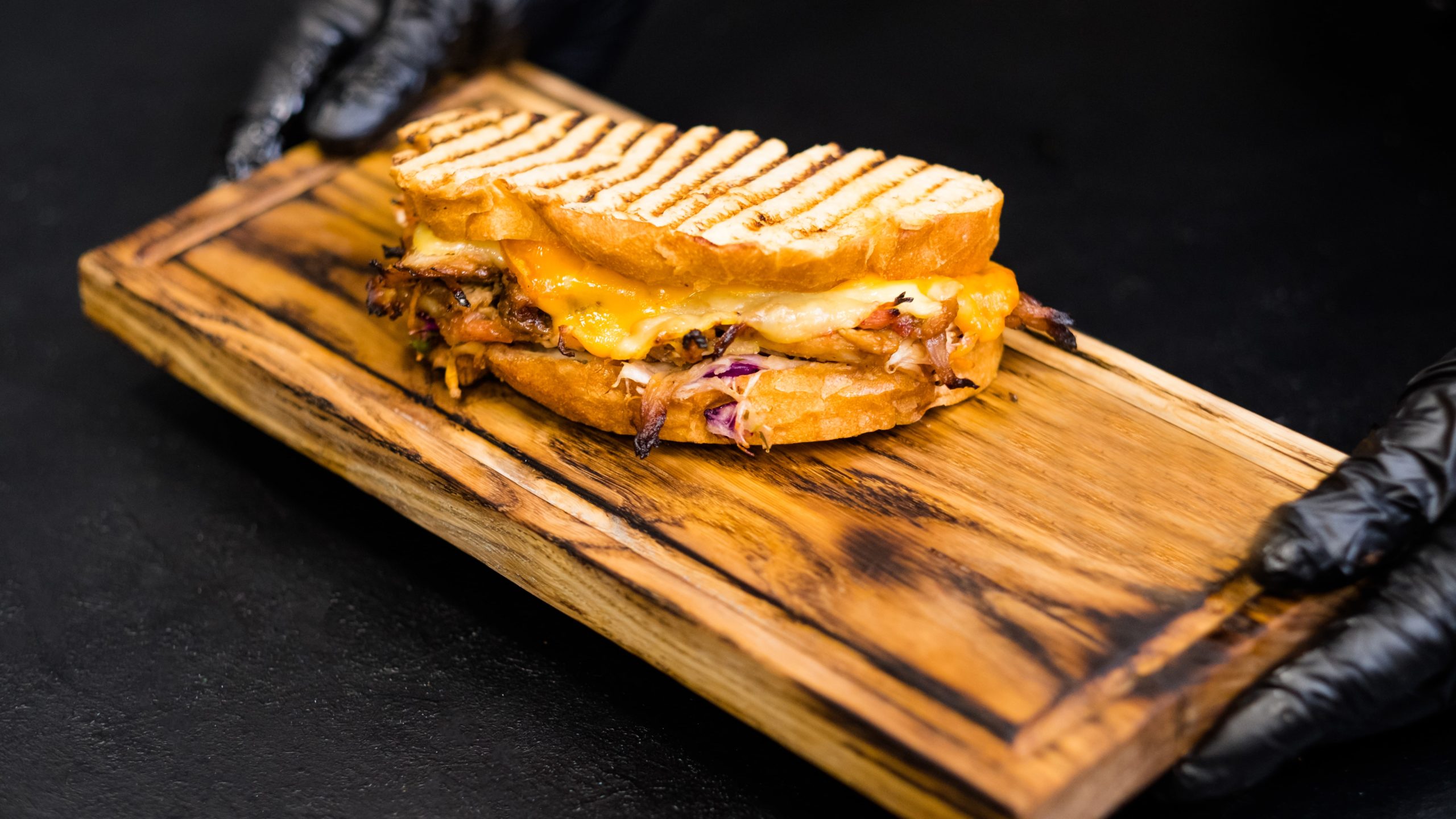 grilled cheese with bbq sauce on a wooden platter